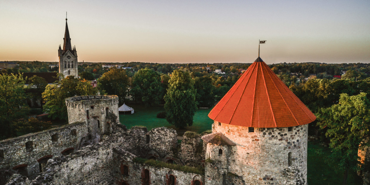 Cēsis: Die Deutschordensburg mit der St.-Johannis-Basilika im Hintergrund