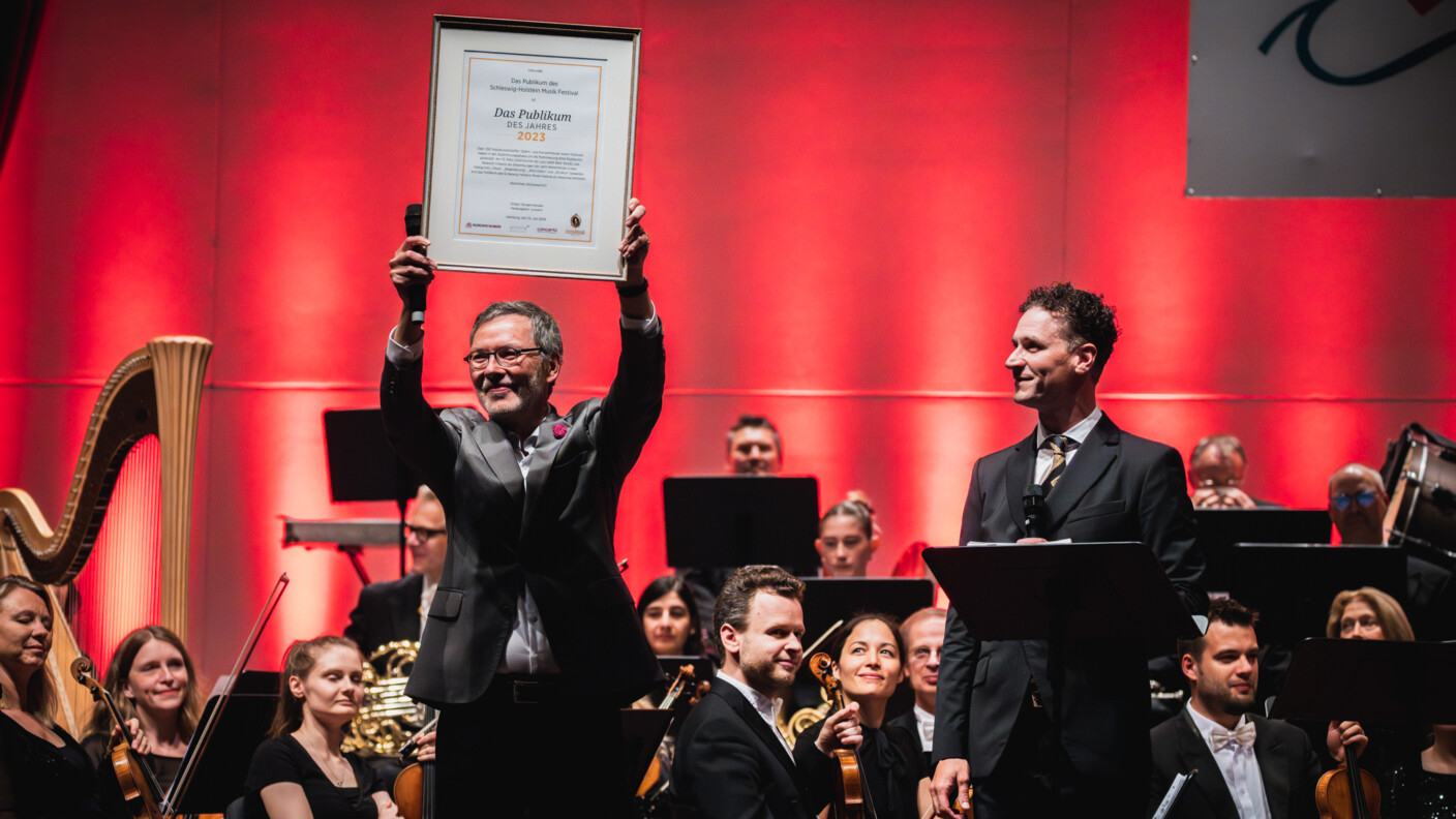 Gregor Burgenmeister, Herausgeber und Chefredakteur von concerti, überreicht SHMF-Intendant Christian Kuhnt die Siegerurkunde